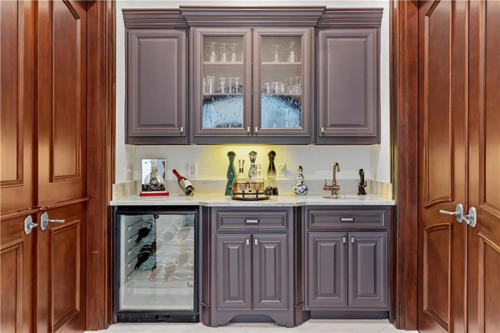 Wet bar with wine refrigerator located between the kitchen and dining room.