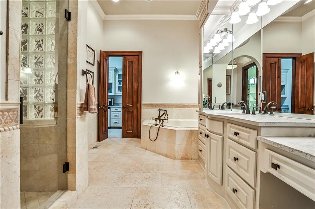 Primary bath with double vanities and commodes, separate shower and whirlpool tub.