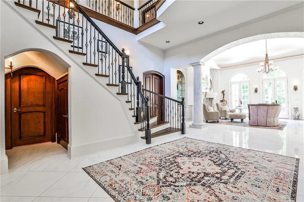 Entrance foyer opens to formal living room. Door under archway leads to library/office.