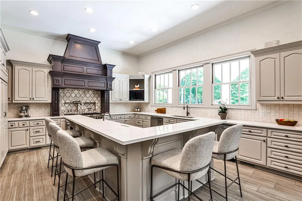 Kitchen with island seating for five, tons of natural light, Sub-Zero, Wolf and Bosch appliances, two sinks, and plentiful counter space.