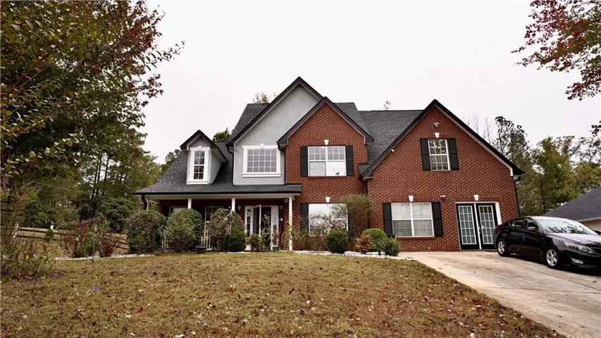 View of front facade featuring a front yard and brick siding