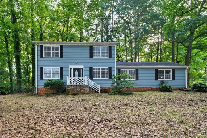 Two-story residence featuring blue siding, white trim, and black shutters
