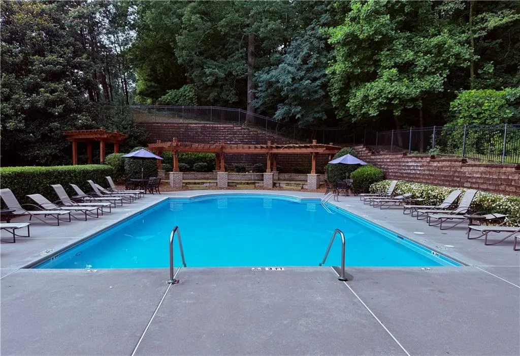 Community pool featuring a patio area and a fenced backyard