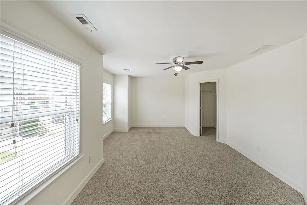 Empty room featuring light carpet and ceiling fan
