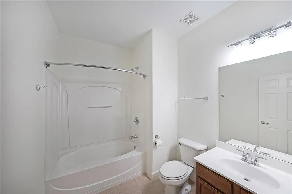 Bathroom with bathtub / shower combination, vanity, and tile patterned floors