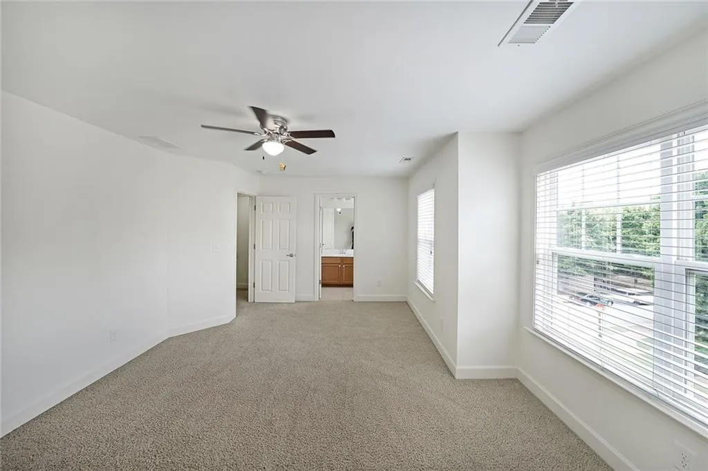 Spare room with a ceiling fan and light carpet