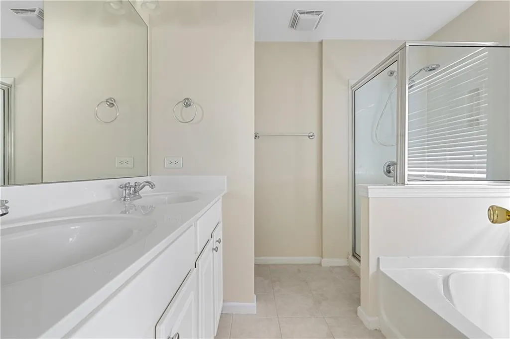 Bathroom featuring visible vents, a sink, a bath, and tile patterned flooring