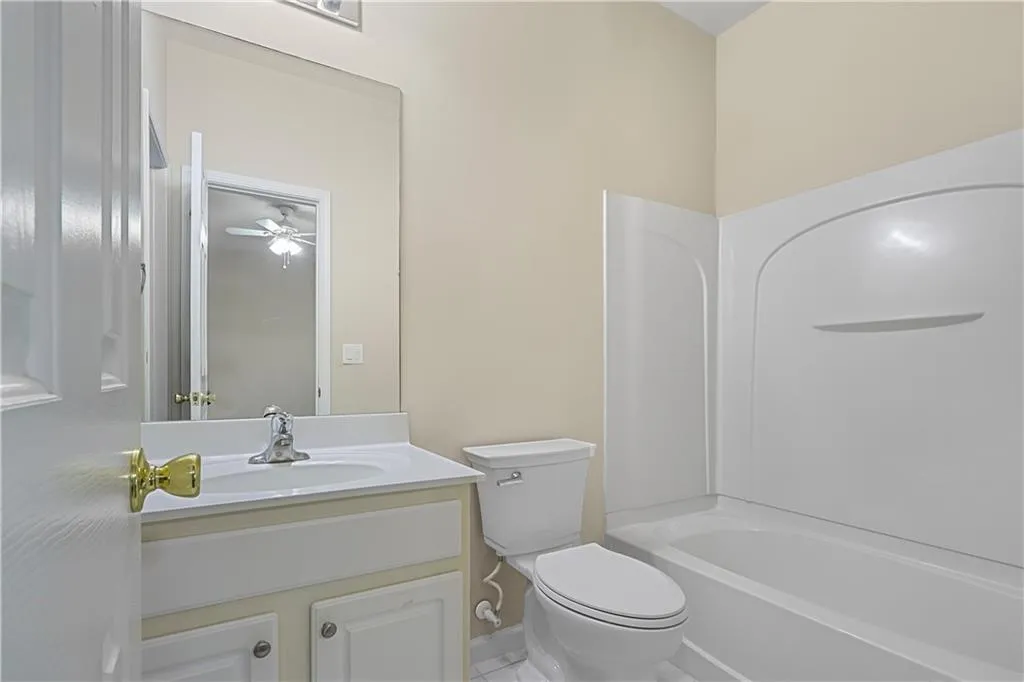 Full bathroom featuring toilet, a ceiling fan, tub / shower combination, and vanity