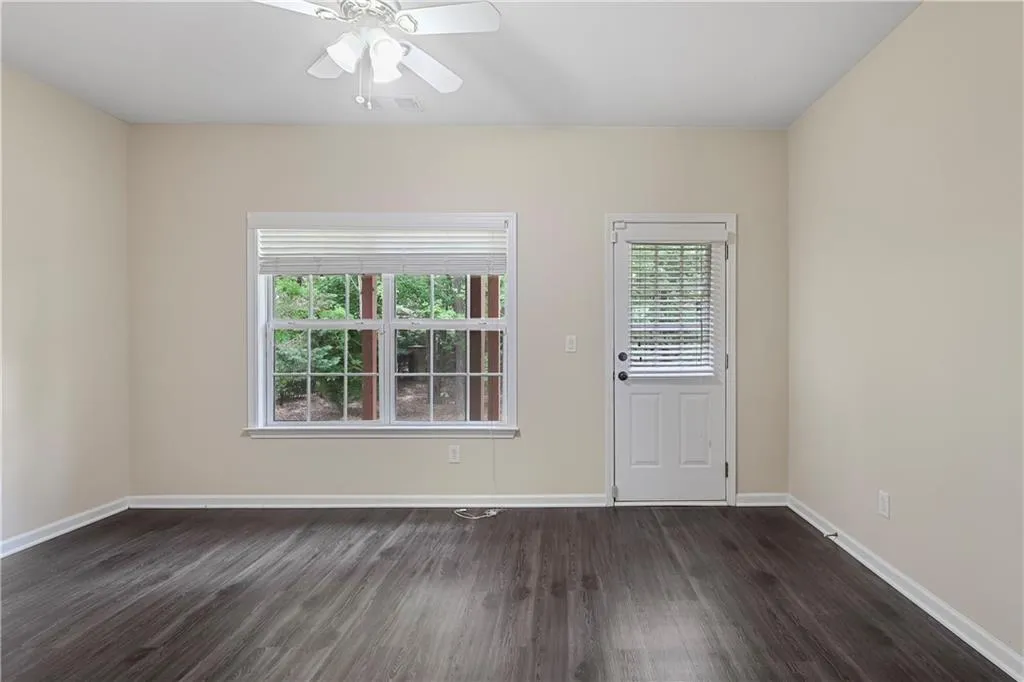 Unfurnished room with baseboards, ceiling fan, dark wood-style flooring, and visible vents