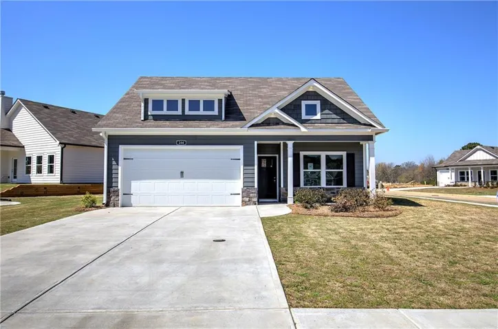Contemporary craftsman exterior featuring dark gray siding, white trim, and stone accents