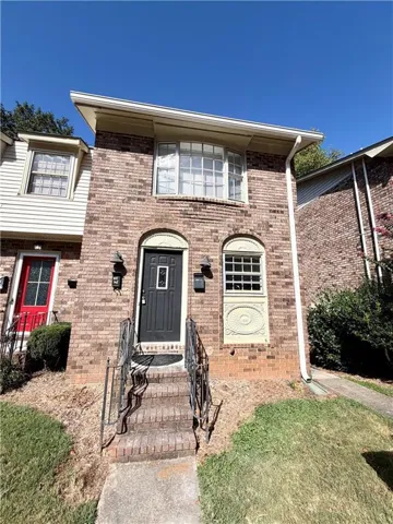 Brick exterior with a curved bay window and a dark entry door
