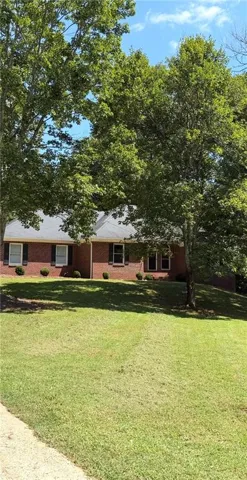 Brick exterior with white window trim and dark shutters