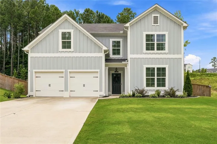 Modern farmhouse-style residence featuring light gray vertical siding with white trim