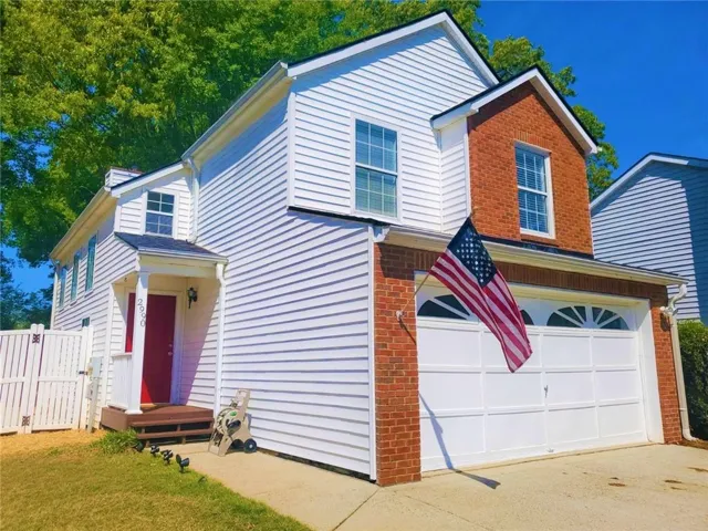 Two-story exterior featuring white siding and brick accents