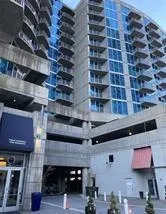 Modern high-rise building with a concrete exterior and expansive blue-tinted windows