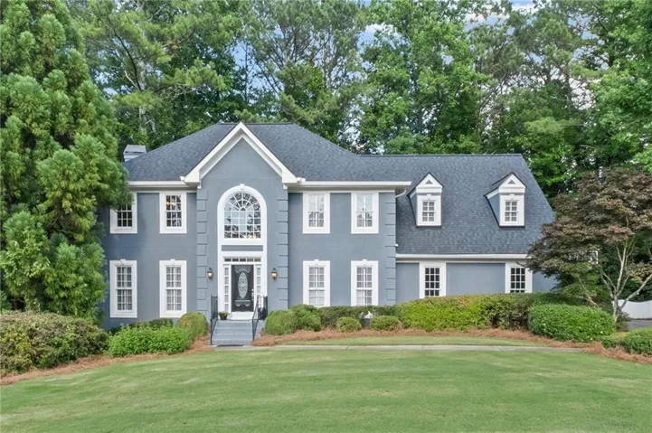 Traditional two-story exterior featuring a gray façade and white trim