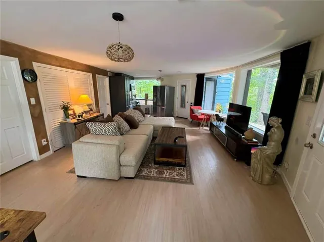 Light wood-finish flooring throughout, a vaulted ceiling, and curved window wall
