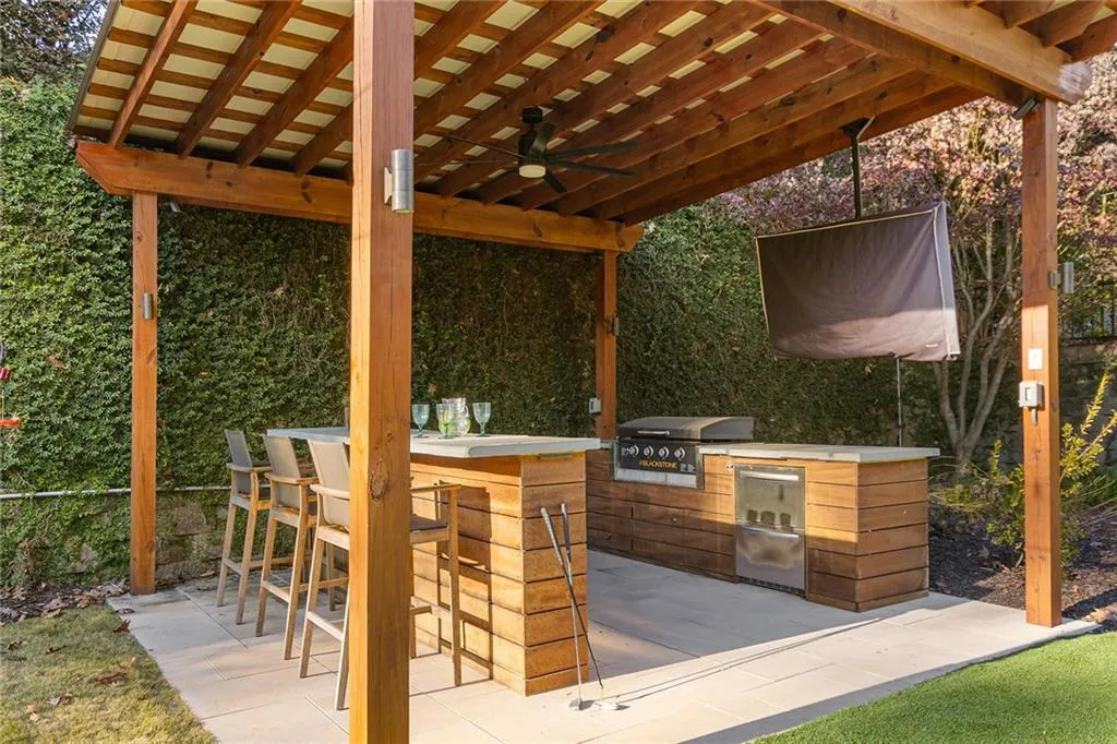 Owner spent over $135K in this backyard renovation to elevate it to resort style living!  You'll be living your dream life at this outdoor kitchen and covered bar area.  Built in Blackstone griddle, built in fridge, outdoor tv - can you think of a better spot to cook for the family?