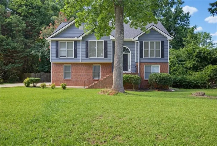Split-level residence featuring a brick and siding exterior with a gabled roof