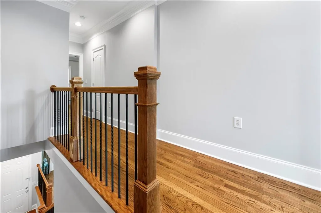 Staircase with ornamental molding, wood finished floors, baseboards, and recessed lighting