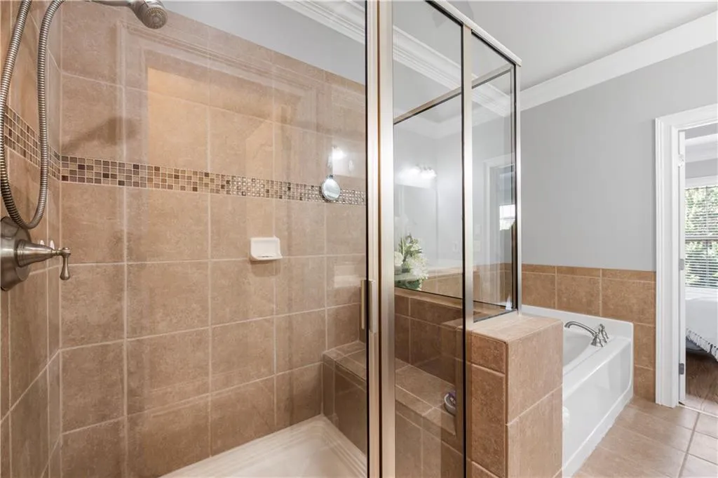 Full bath featuring ornamental molding, a stall shower, a bath, and tile patterned floors