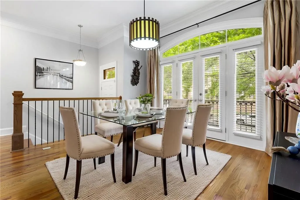 Dining space featuring wood finished floors, ornamental molding, and baseboards