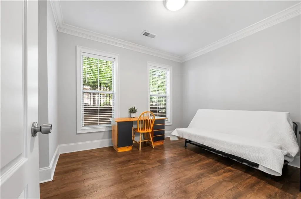 Office space featuring ornamental molding, wood finished floors, and baseboards