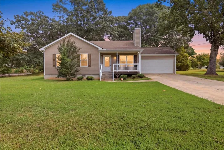 Siding exterior with a covered porch, attached garage, and a concrete driveway