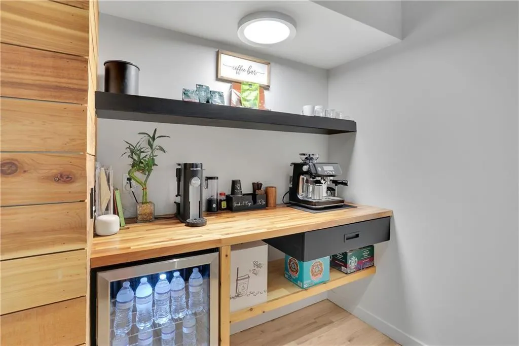 Bar area featuring beverage cooler, butcher block countertops, and light wood-style flooring