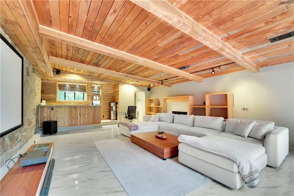 Living room featuring marble finish floors, a wood ceiling with exposed beams, and wooden walls