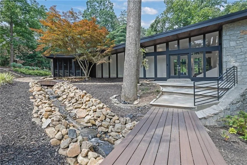 Back of house with a sunroom and stone siding