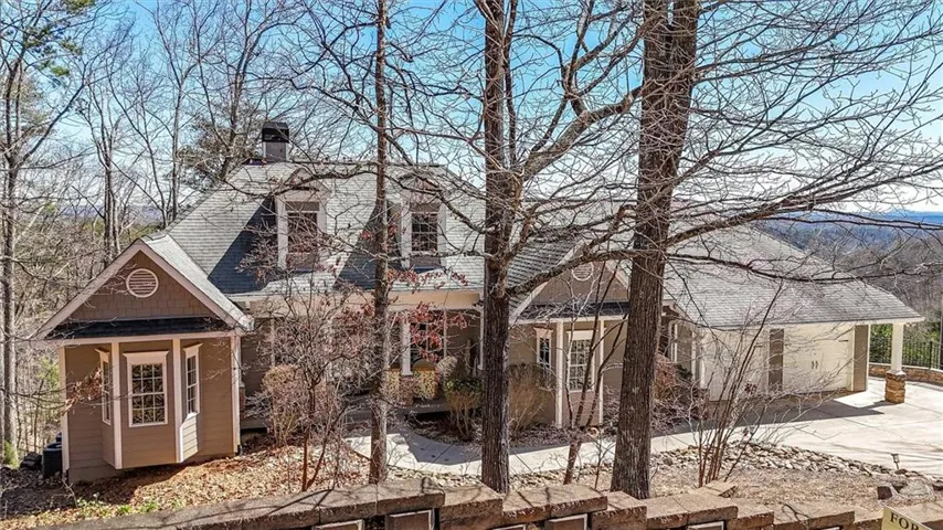 View of front of home with a chimney and roof with shingles