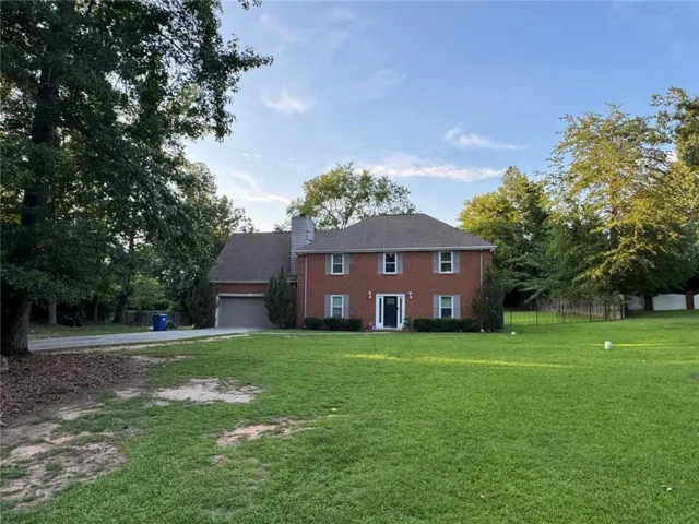 Brick-clad residence featuring a gabled roofline and attached two-car garage