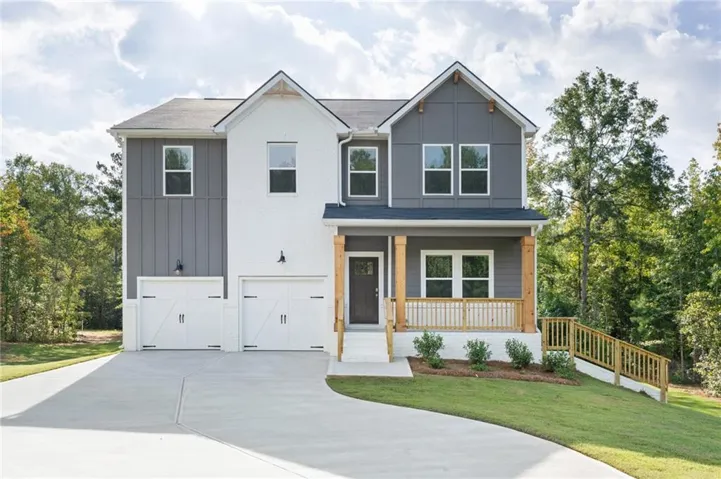Modern exterior featuring a covered porch with natural wood columns, a two-car garage with carriage-style doors, and a concrete driveway