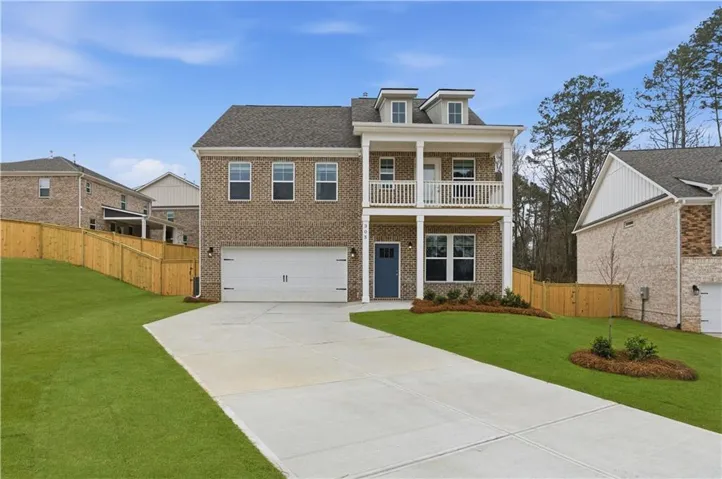 Brick exterior with a two-car garage, a covered entry, and an upper-level balcony
