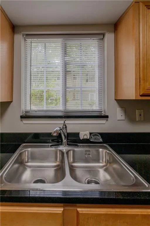 Kitchen view of dark countertops and brown cabinets