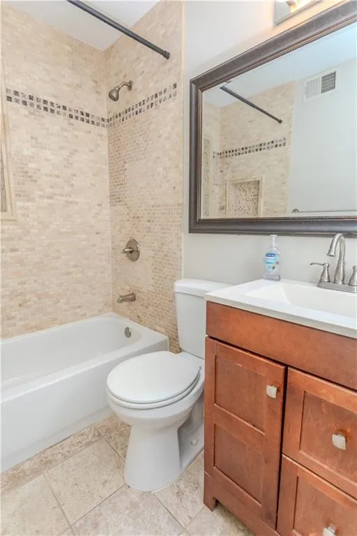 Full bathroom with washtub / shower combination, vanity, and tile patterned flooring