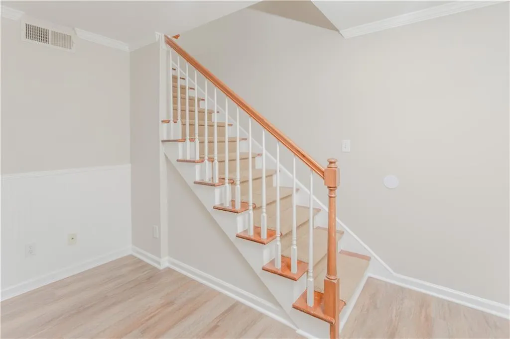 Stairs with ornamental molding and wood finished floors