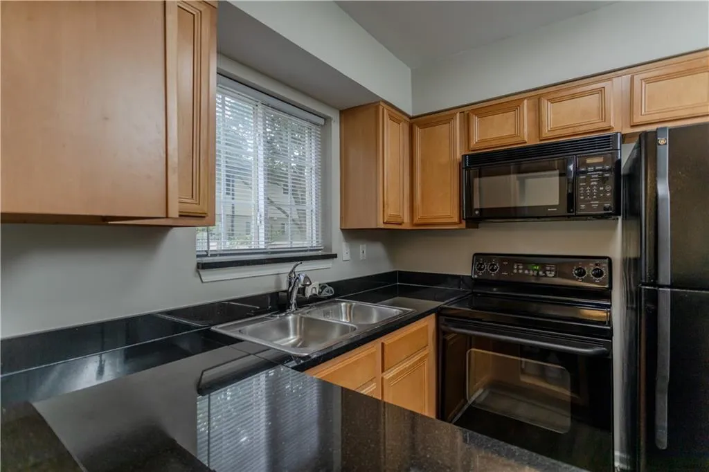 Kitchen featuring black appliances and dark countertops