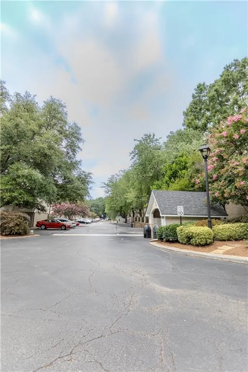 View of asphalt street featuring street lighting and curbs