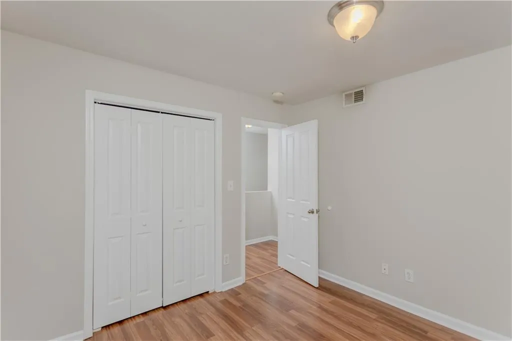 Unfurnished bedroom with light wood-style flooring and a closet