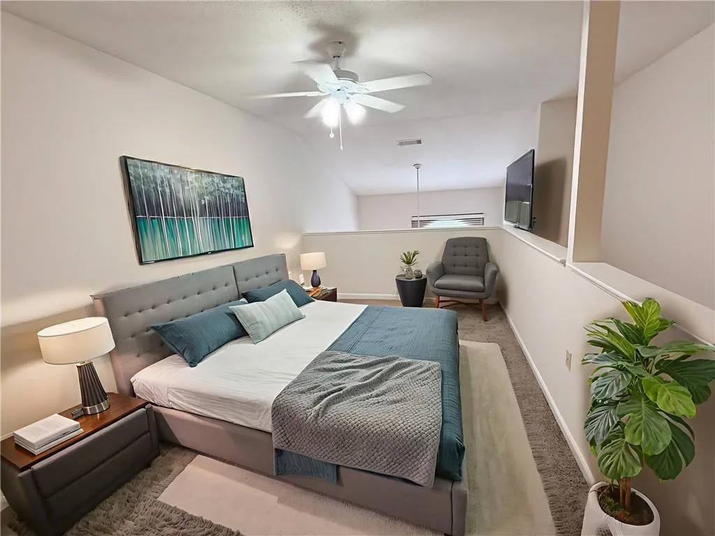 Carpeted bedroom with baseboards and a ceiling fan