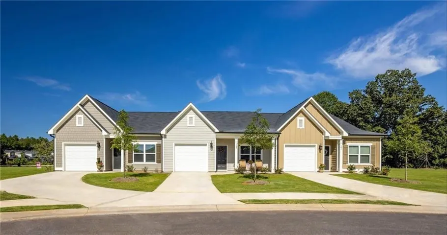 Single story home with a front yard, a porch, driveway, and a garage