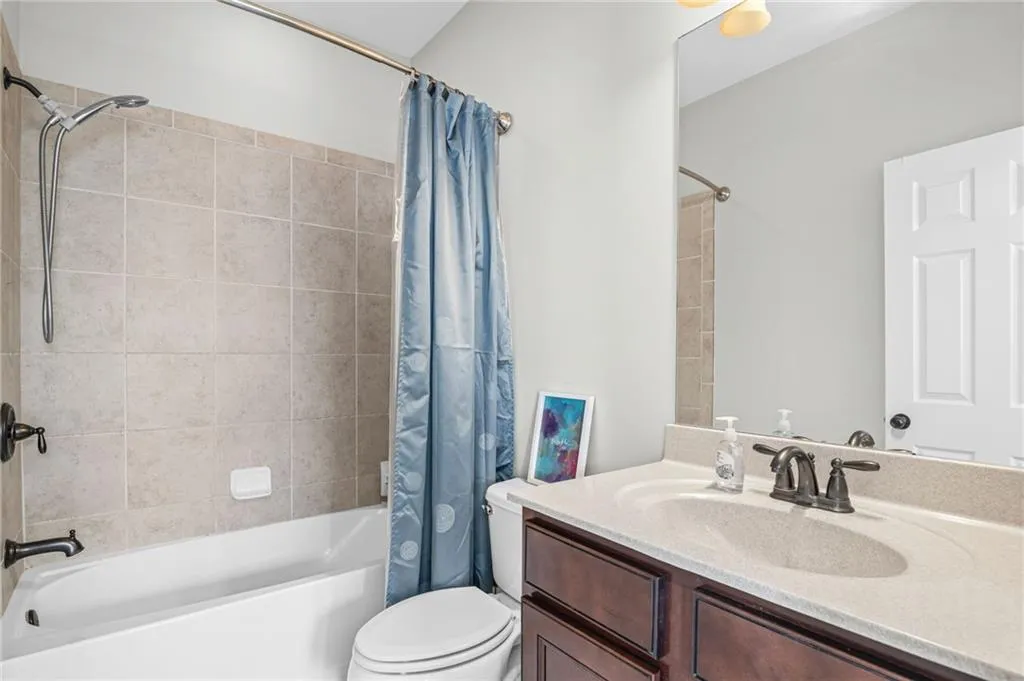 En-suite bathroom featuring vanity and shower / bath combo