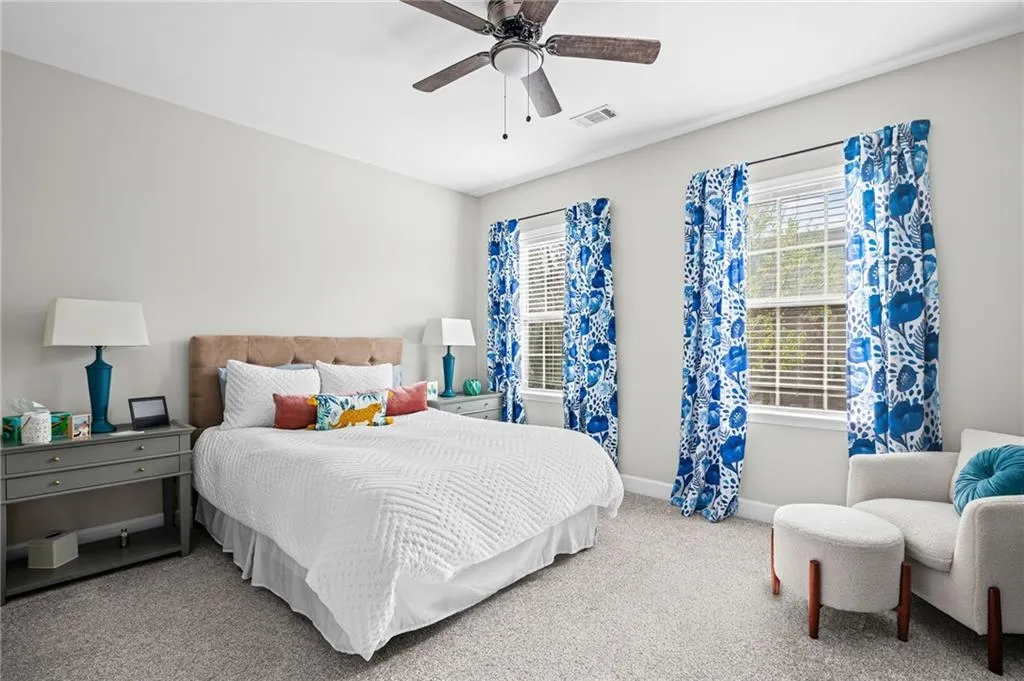Carpeted bedroom with ceiling fan and baseboards