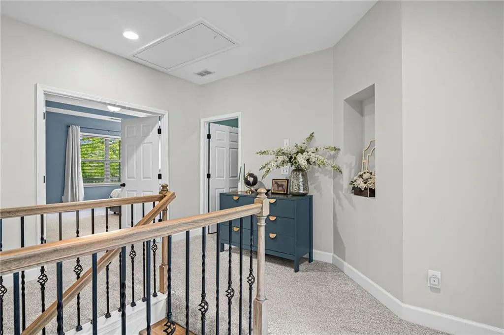 Hall featuring an upstairs landing, light carpet, and recessed lighting