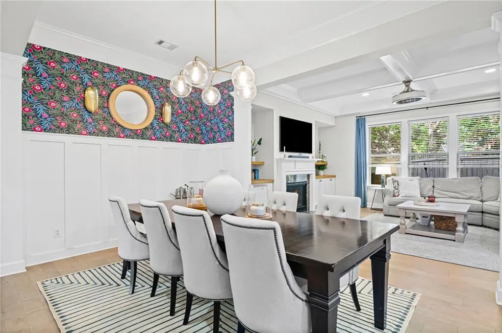 Dining room with a decorative wall, wainscoting, and light wood-type flooring