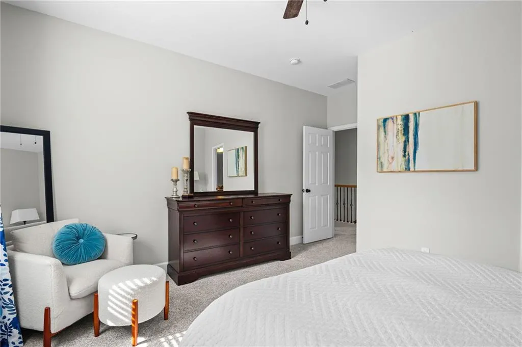 Bedroom with light colored carpet and a ceiling fan