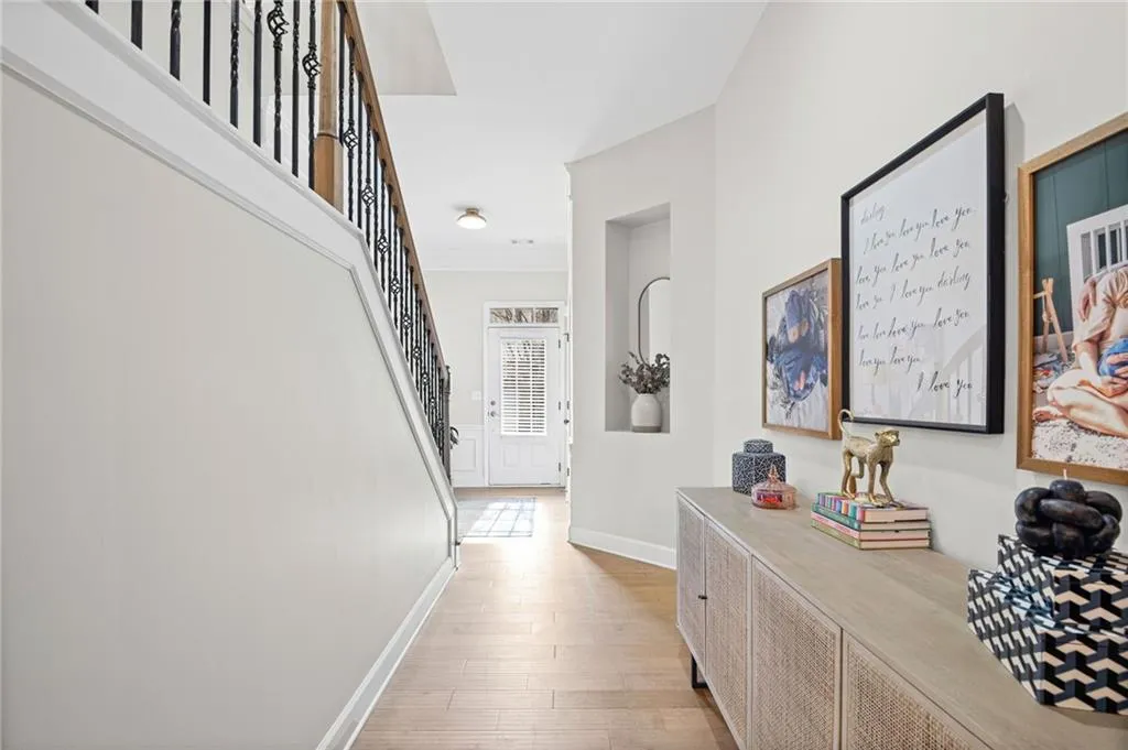 Hallway featuring light wood-style flooring and ornamental molding