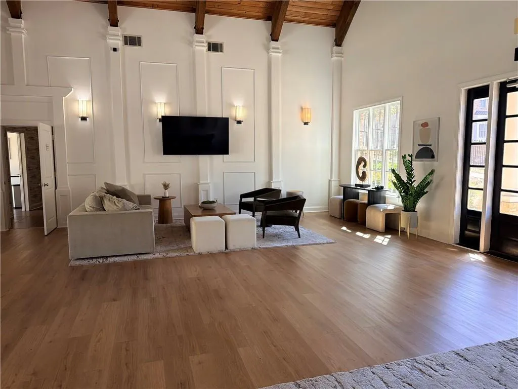 Clubhouse community room featuring wood finished floors, a high wood beamed ceiling, and a decorative wall